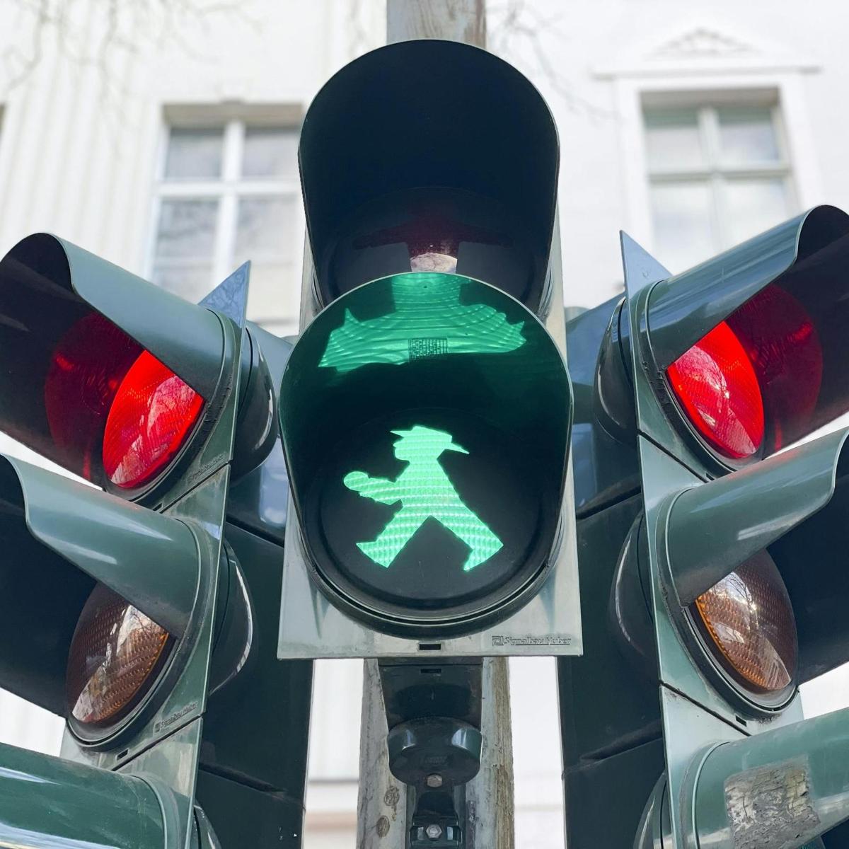 un feu de circulation avec un panneau de marche vert dessus