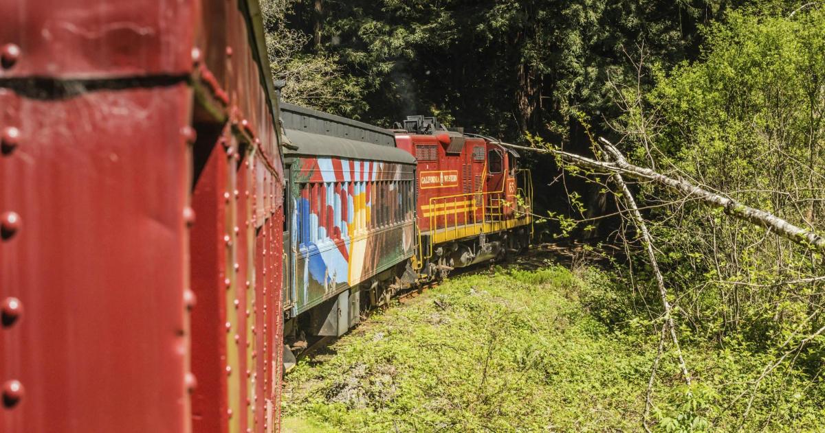 a red train is traveling down the tracks