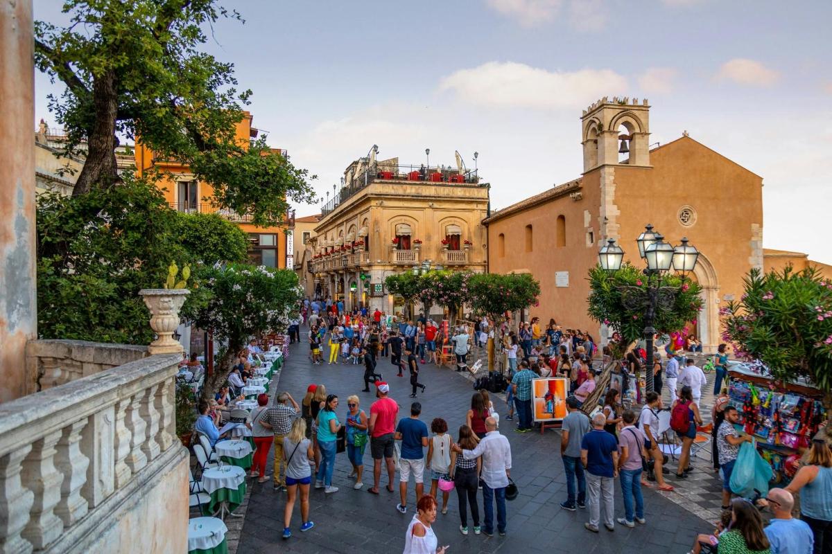 a crowd of people walking down a street in a city