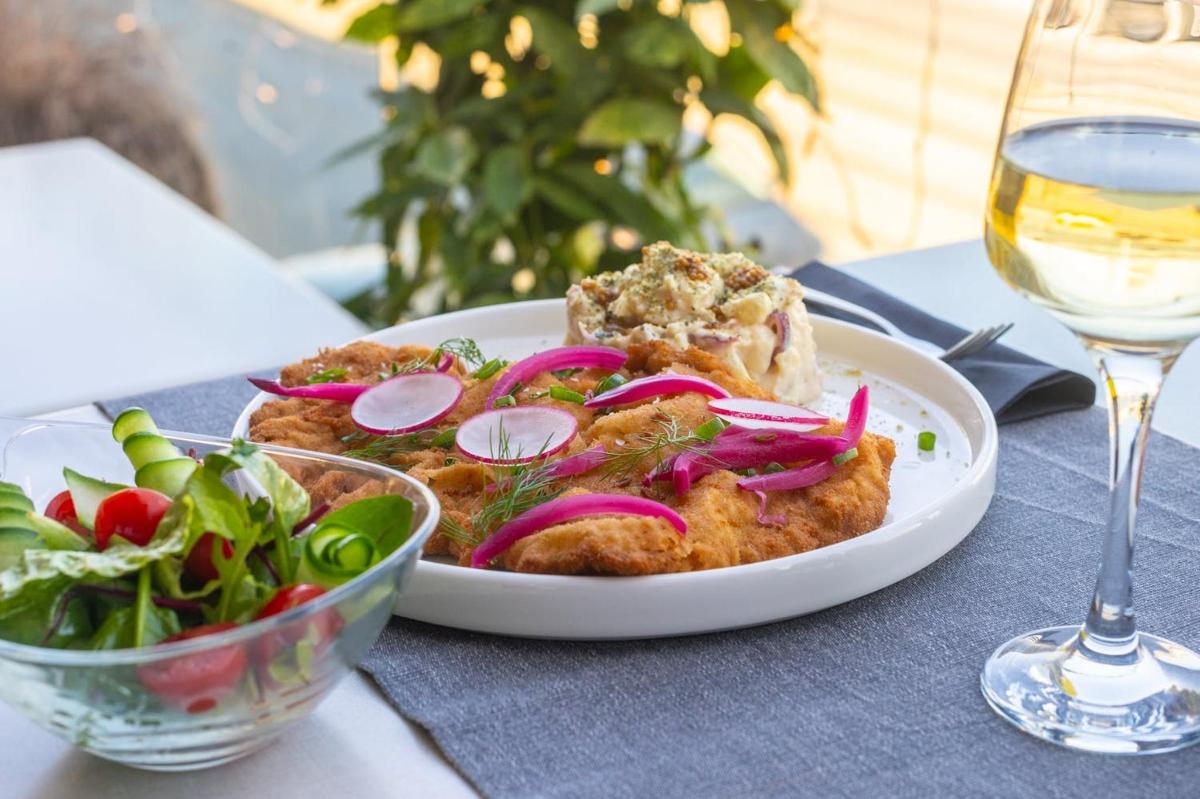 a plate of food with a salad and a glass of wine