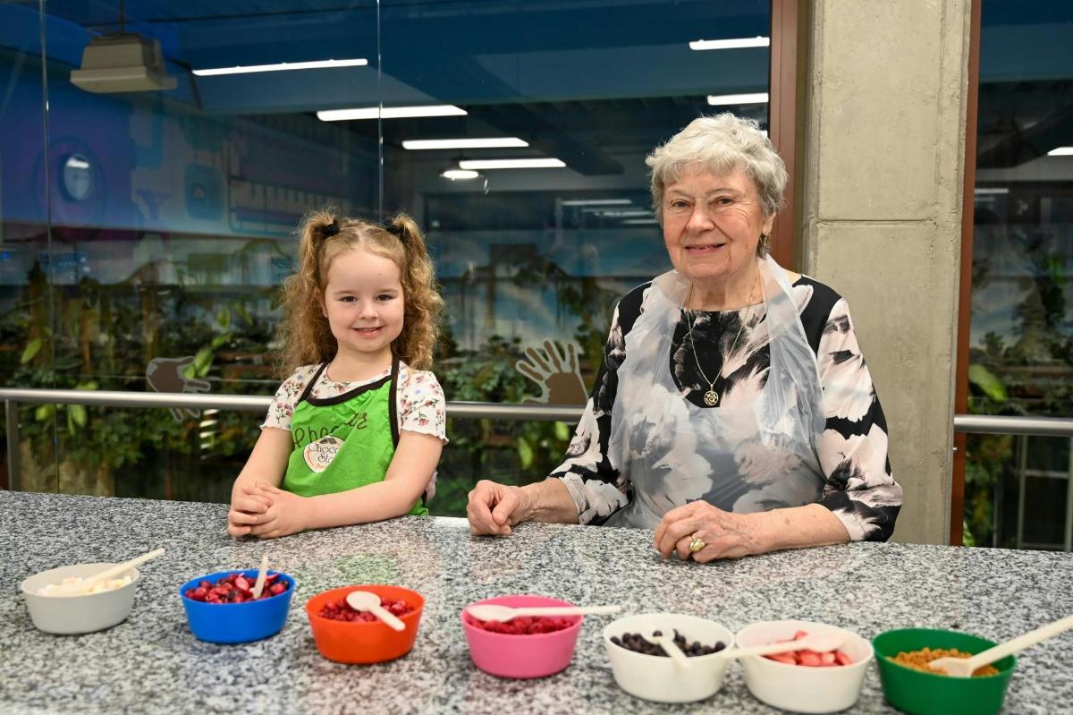 a woman and a little girl sitting at a table with bowls