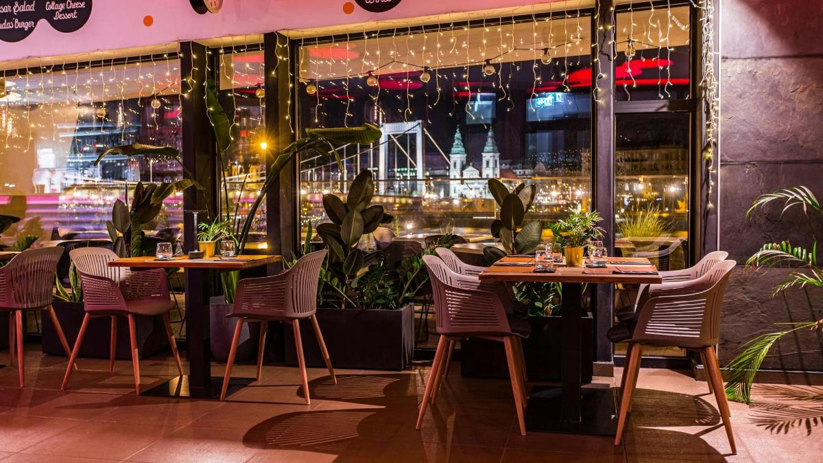 a restaurant with tables and chairs in front of a window