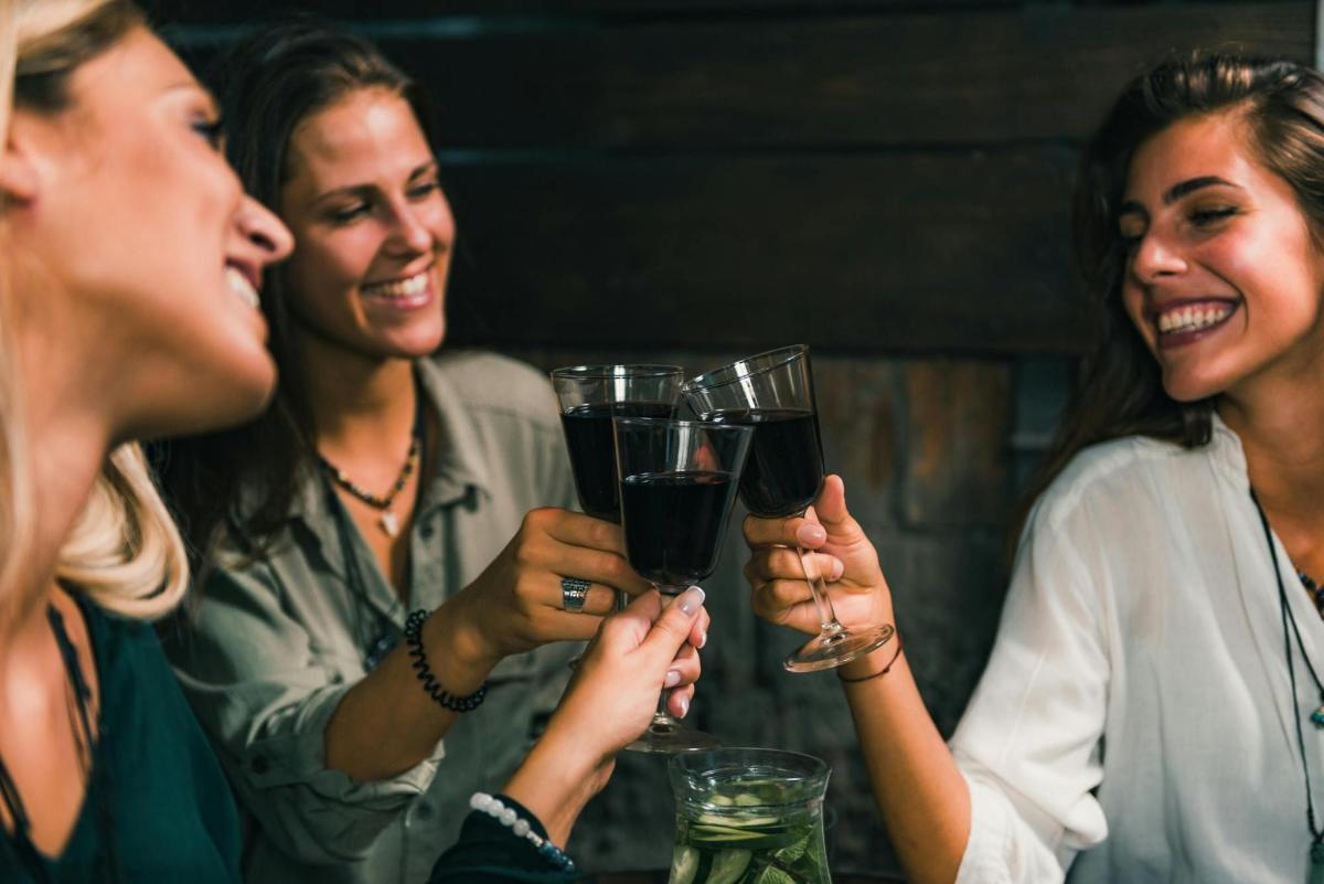 a group of women holding up glasses of wine