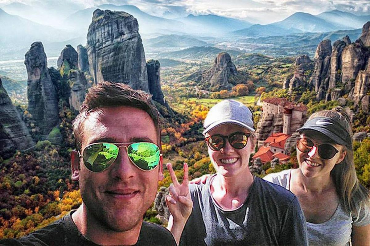 three people posing for a picture in the mountains