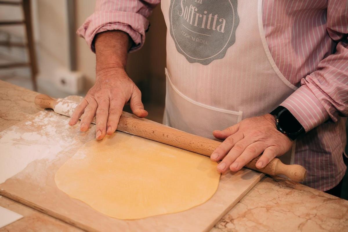 a man is making a dough on a cutting board