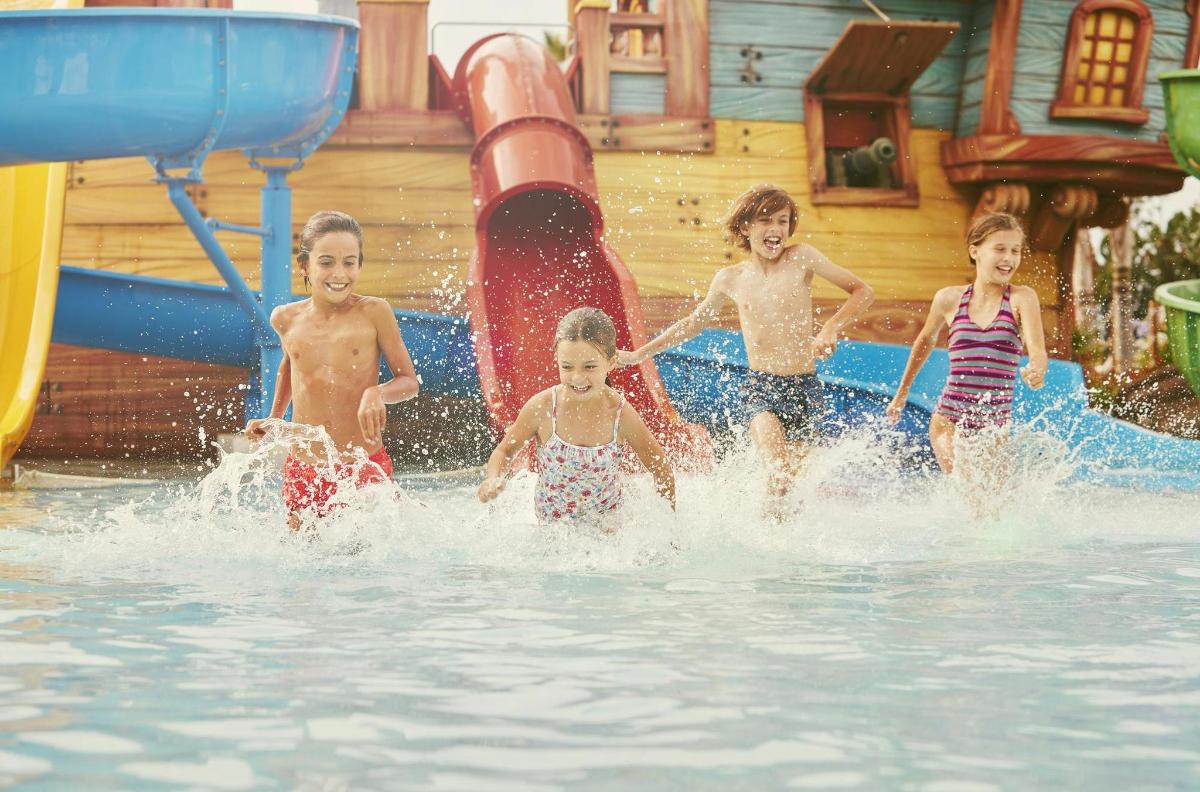 a group of children playing in a water park