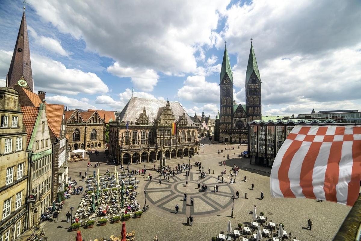 a group of people walking around a plaza in a city