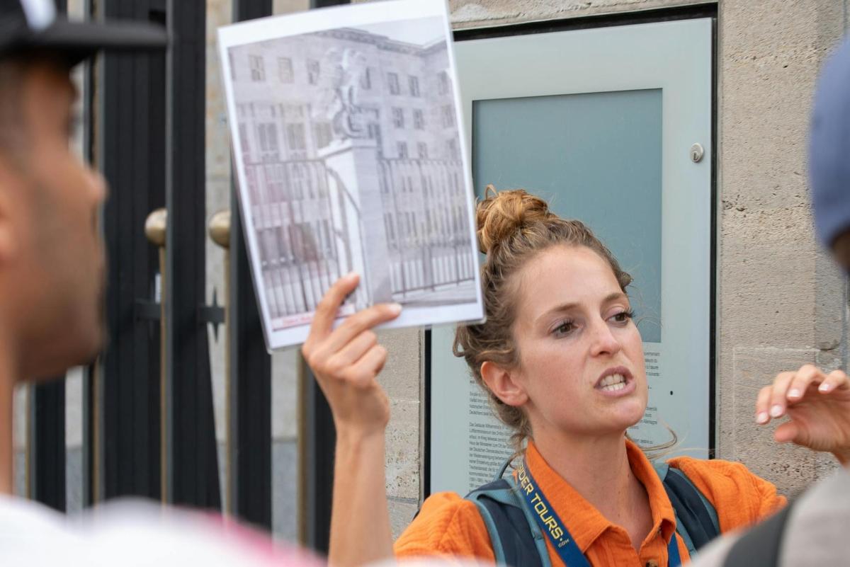 a woman holding up a picture of a building