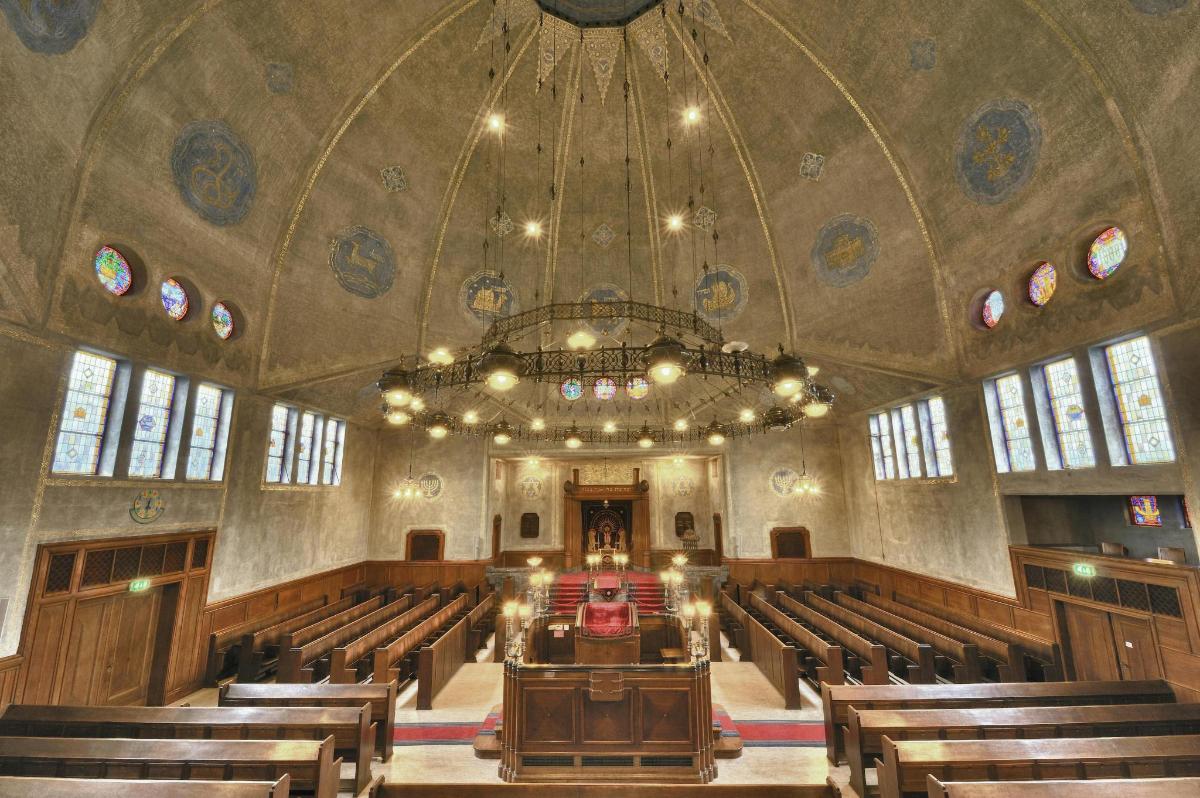 an empty church with a chandelier and pews