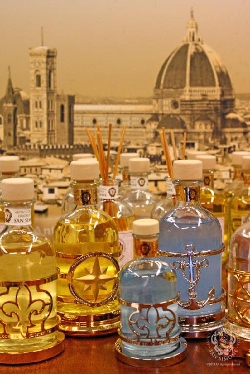 a group of bottles of oil on a table with a city in the background
