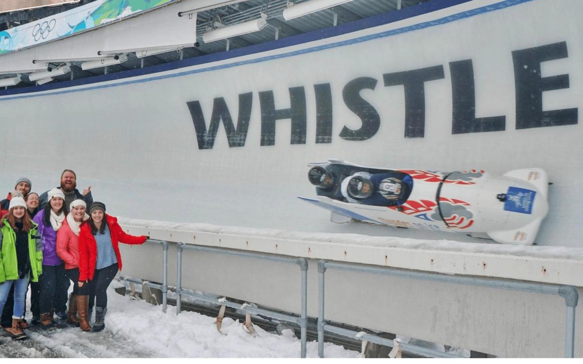 a group of people standing in the snow in front of a whittelle