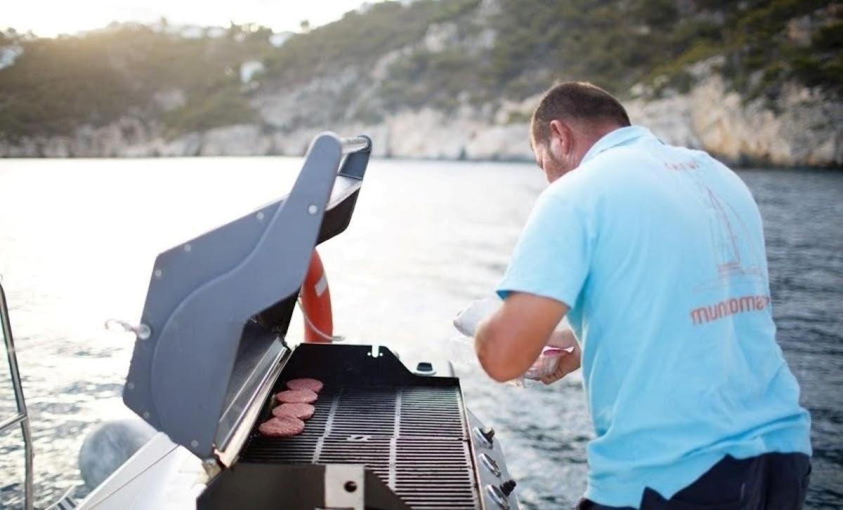 a man is cooking food on a grill on a boat