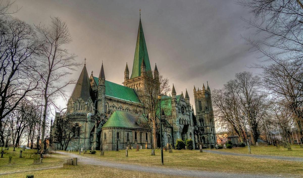 a large cathedral with a green roof in a park