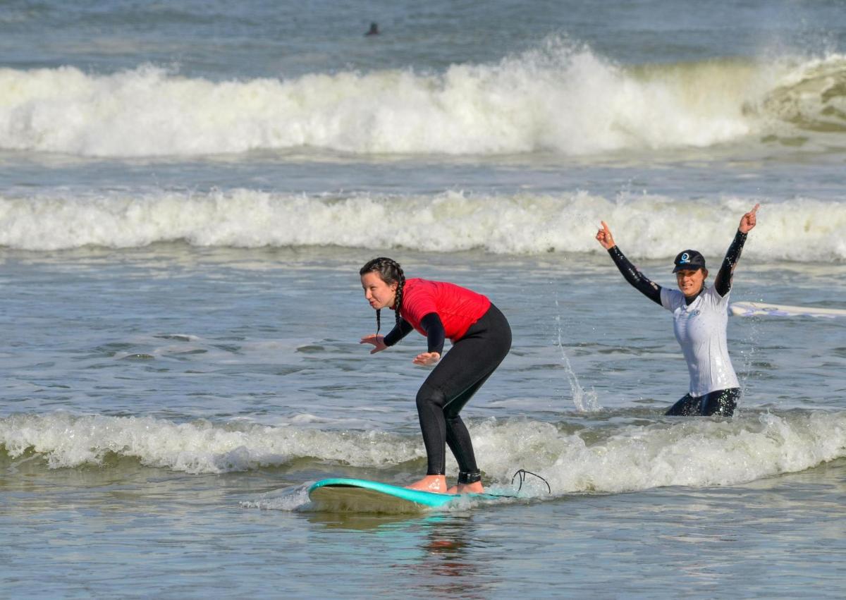 two people riding a wave on a surfboard in the ocean