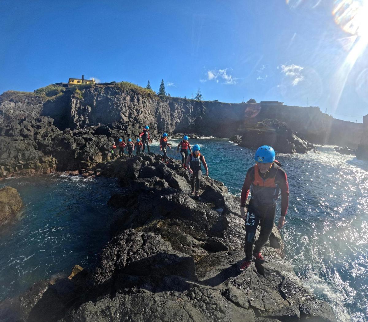 a group of people standing on rocks near the water