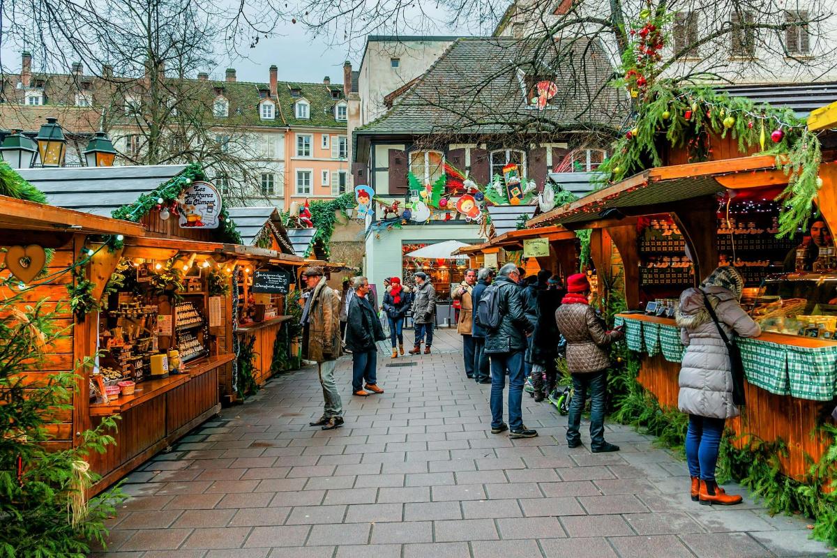 a group of people walking through a christmas market