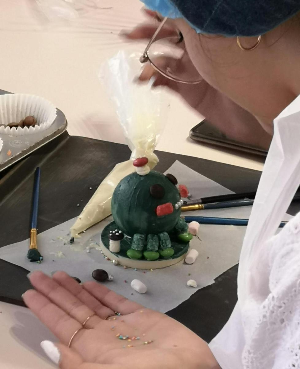 a woman with her hand on a cake with a candle