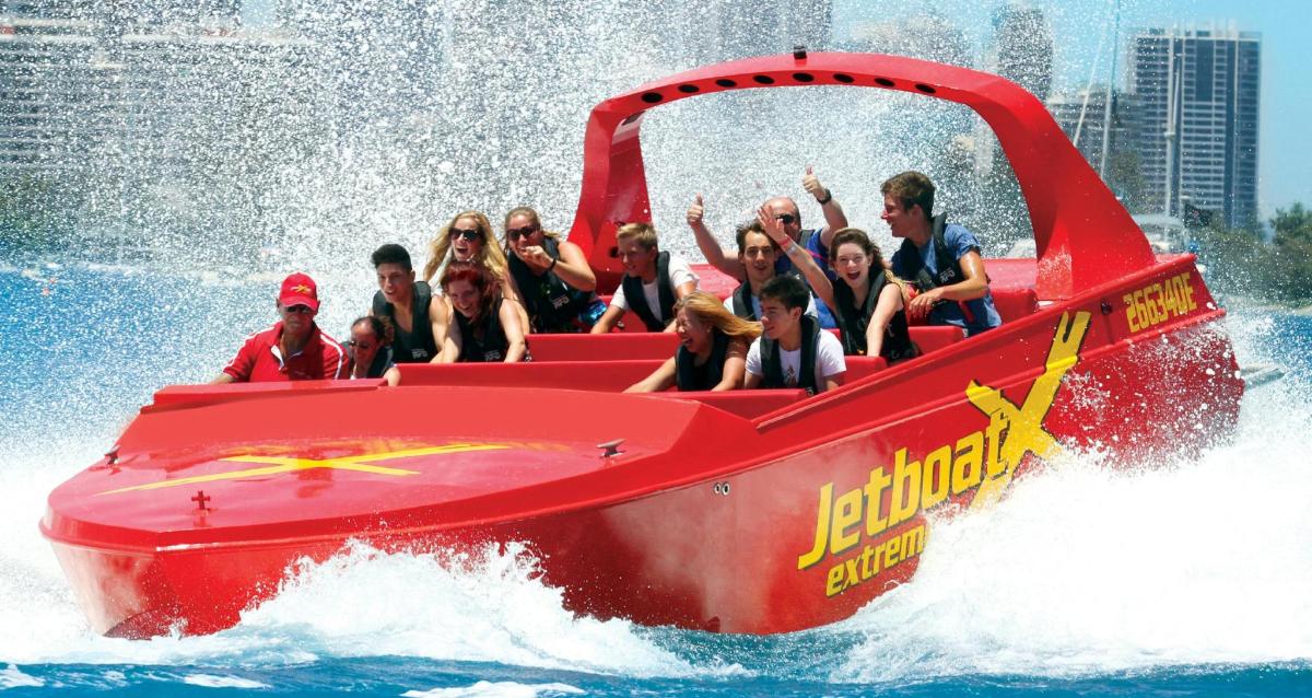 a group of people riding on a red boat in the water