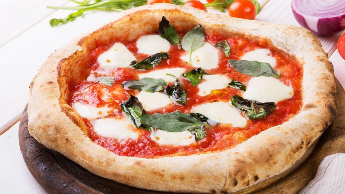 a pizza sitting on top of a wooden plate