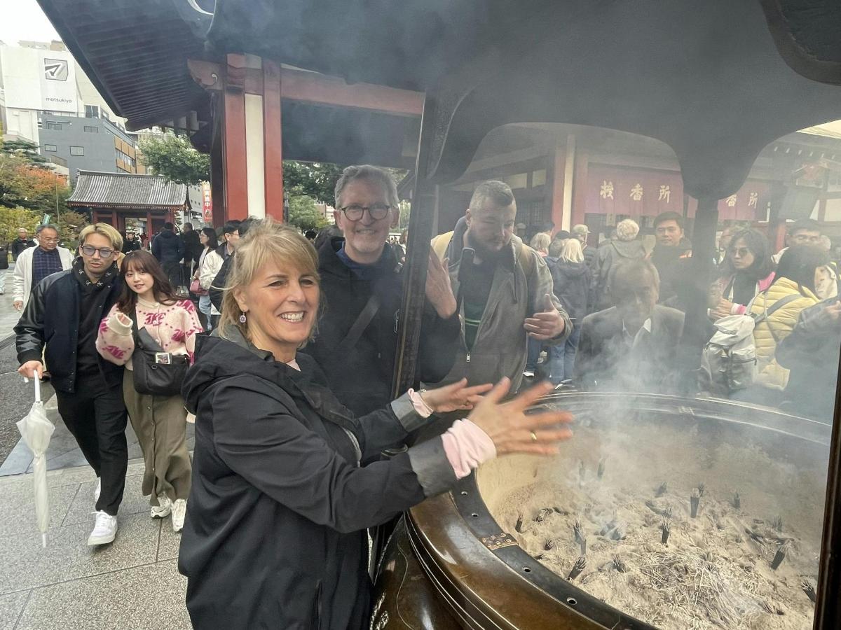 a group of people standing around a large grill