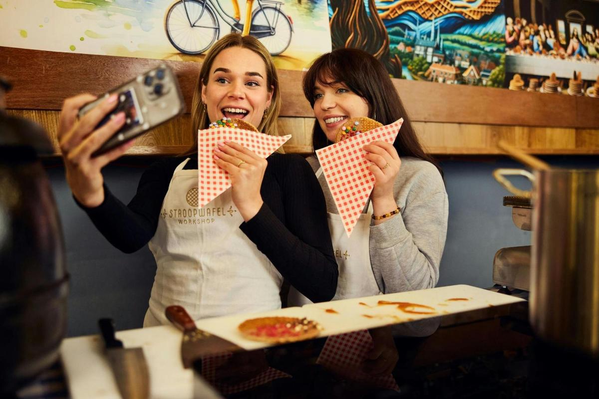 two women sitting at a table eating pizza