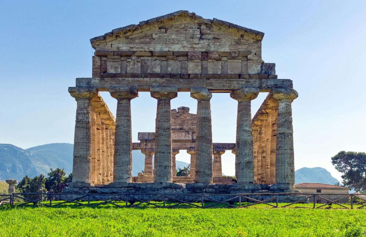 an ancient temple with columns in a field