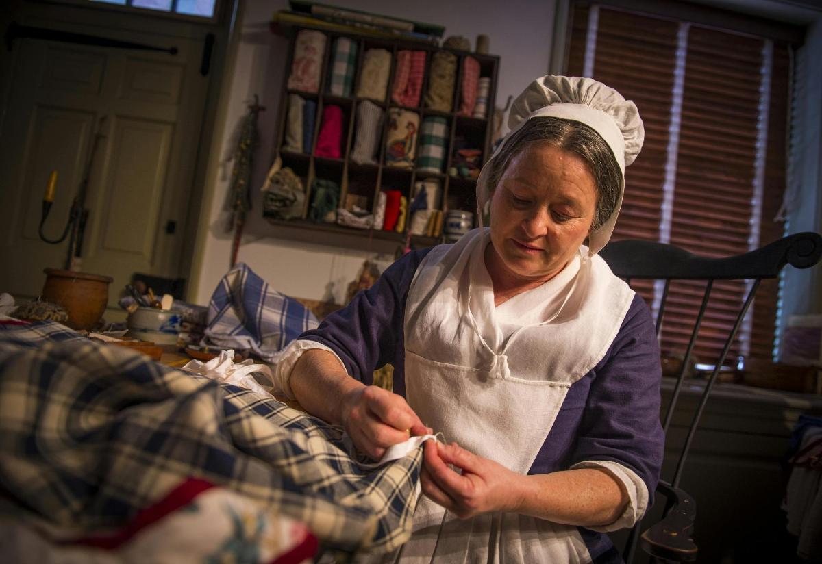 a woman standing in a kitchen preparing food