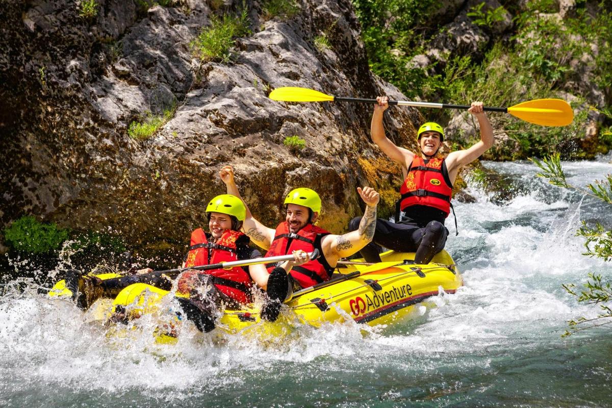 three people are on a raft in the water