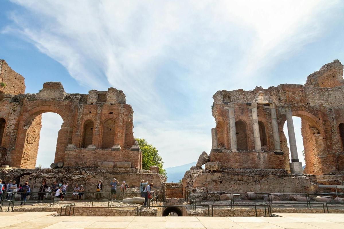 a group of people standing in front of the ruins