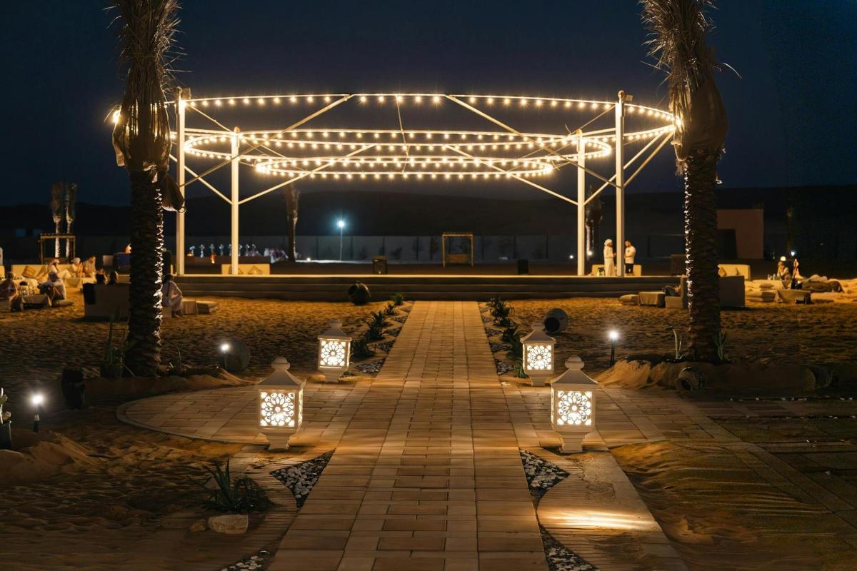 a pavilion with lights and palm trees at night