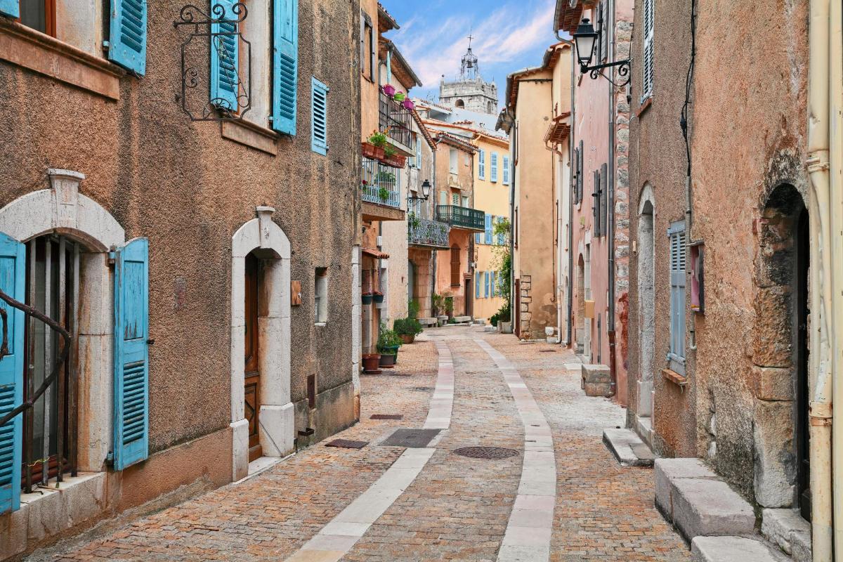 an alley in an old town with blue shutters