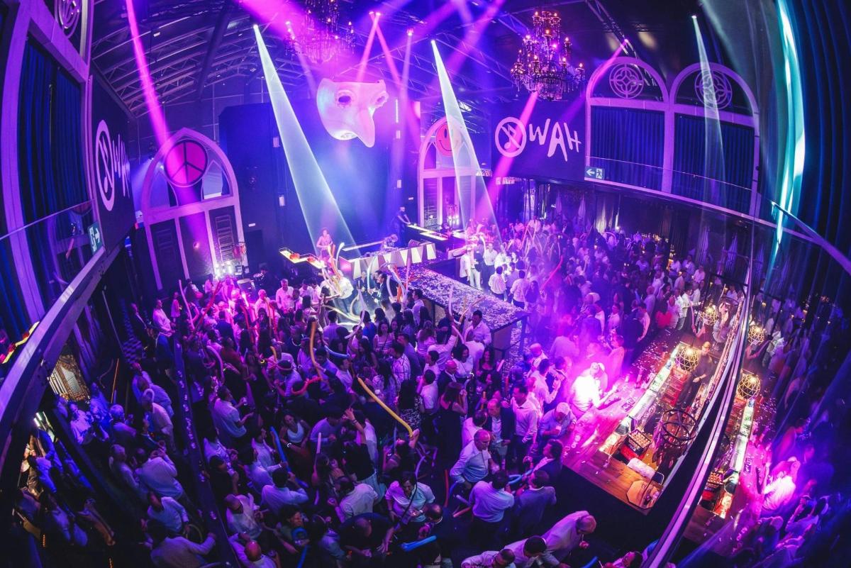 a crowd of people in a room with purple lights