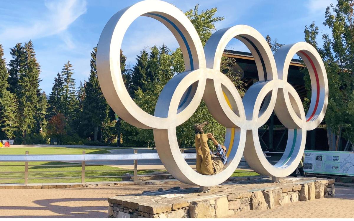 a statue of a person standing next to the olympic rings