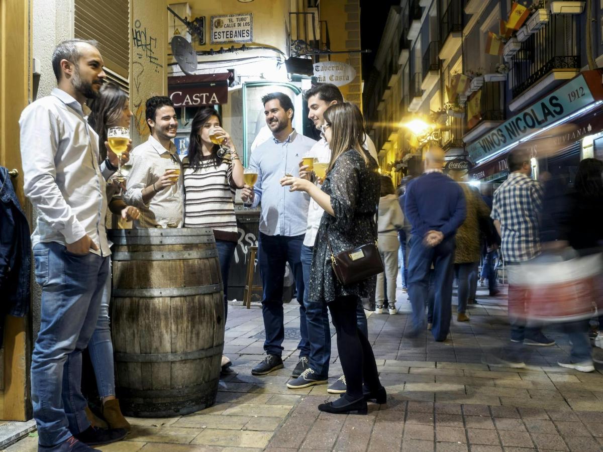 a group of people standing around a barrel on a street