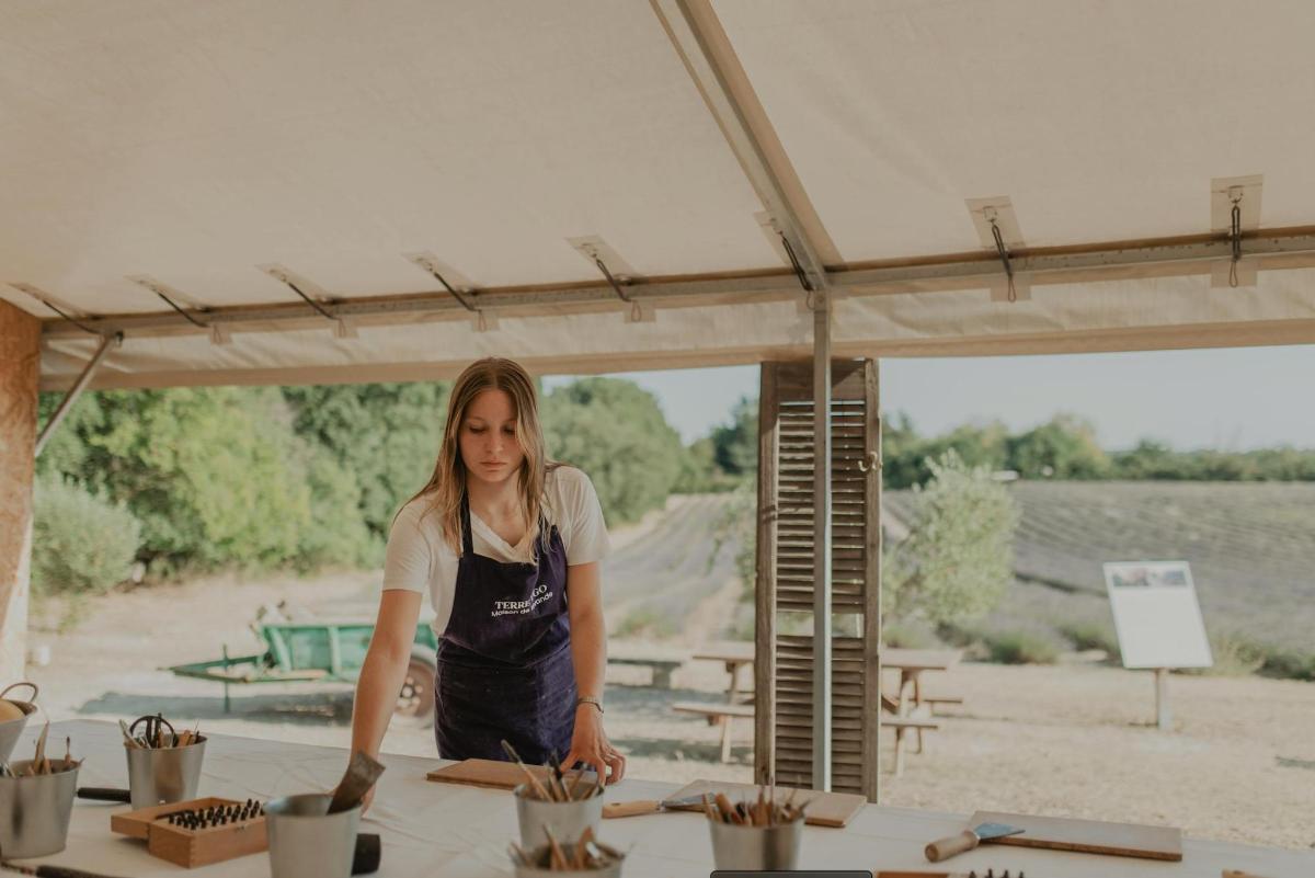 a woman standing under a tent preparing food
