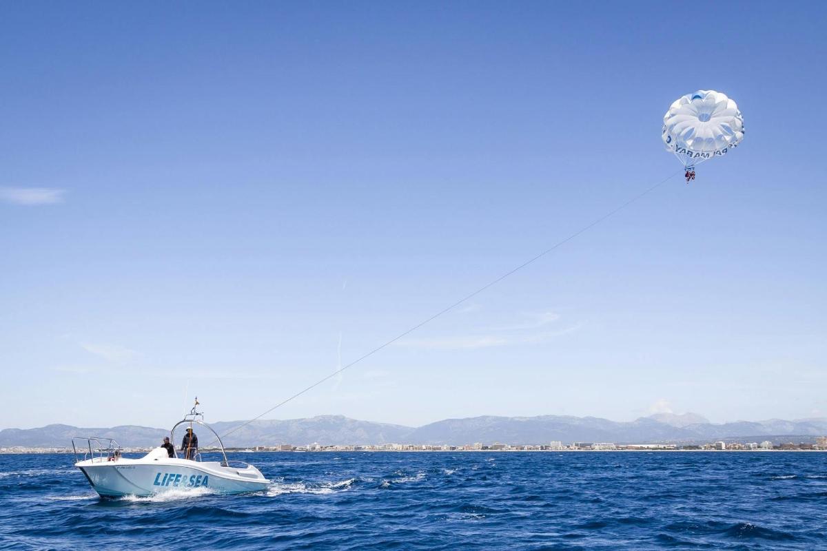 a man in a boat in the water with a kite