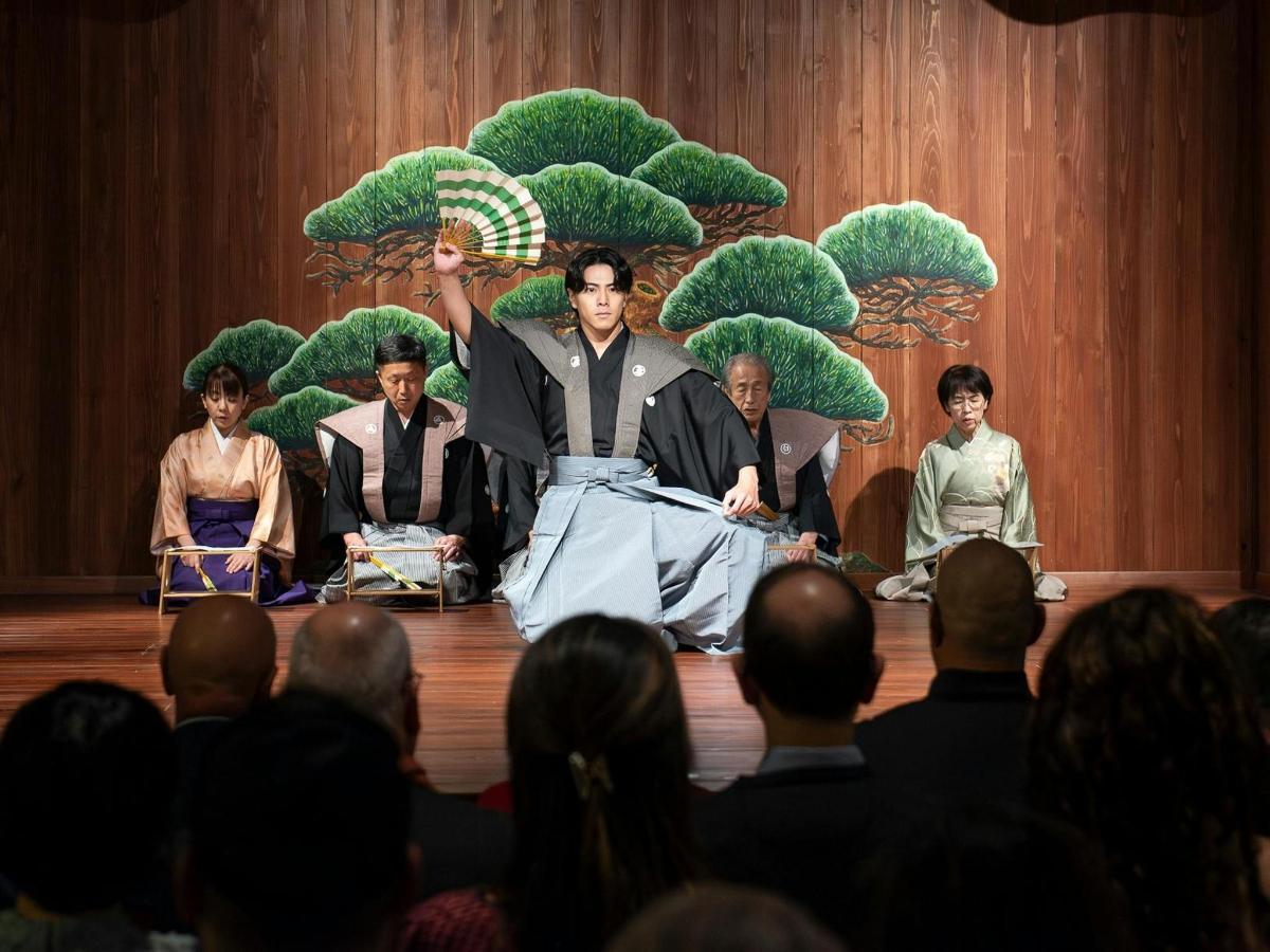 a group of people watching a man perform on a stage