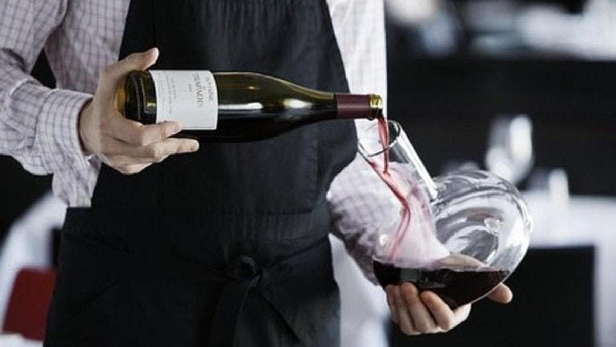 egy személy bort önt egy pohárba