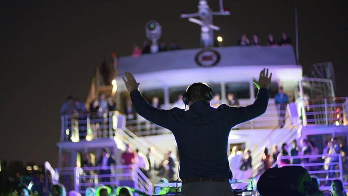 a man standing in front of a boat with his hands up