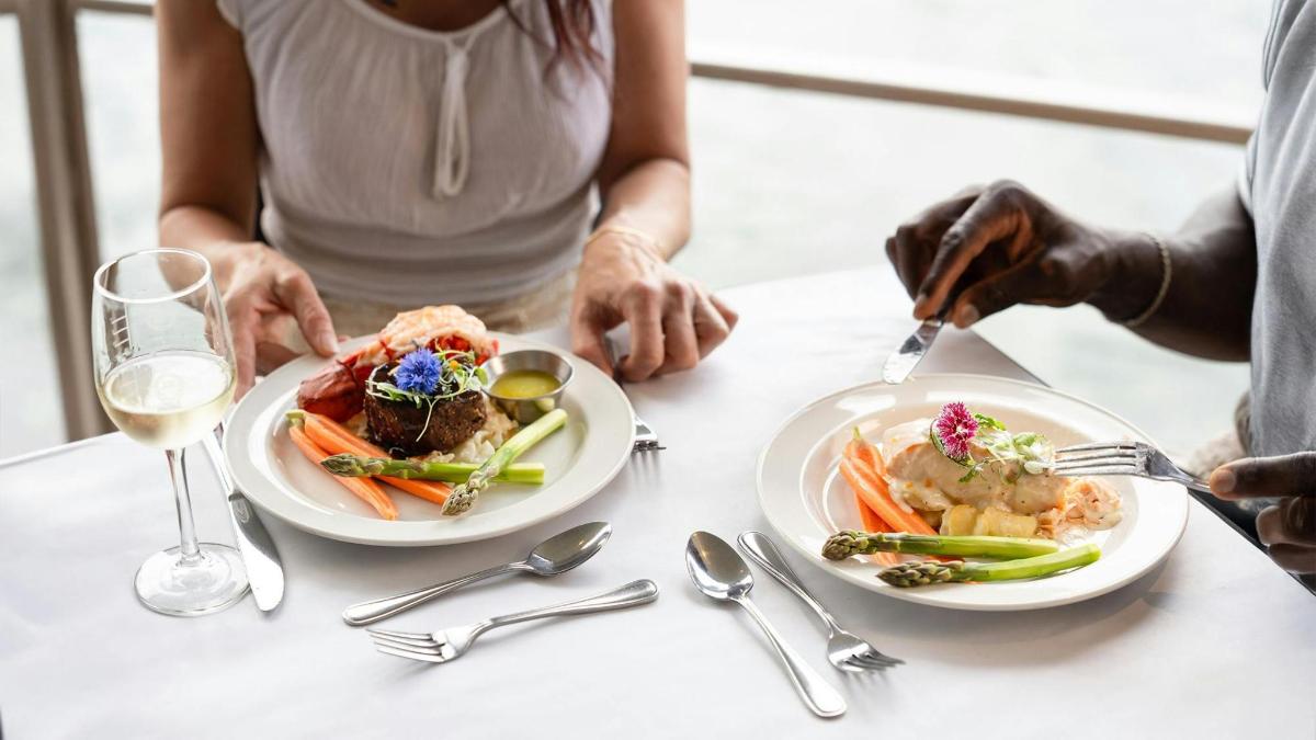 a person sitting at a table with two plates of food