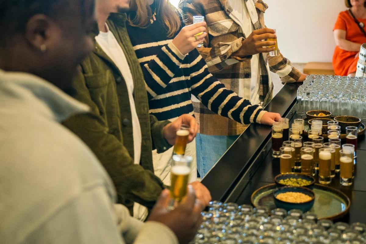 a group of people standing around a bar with beer