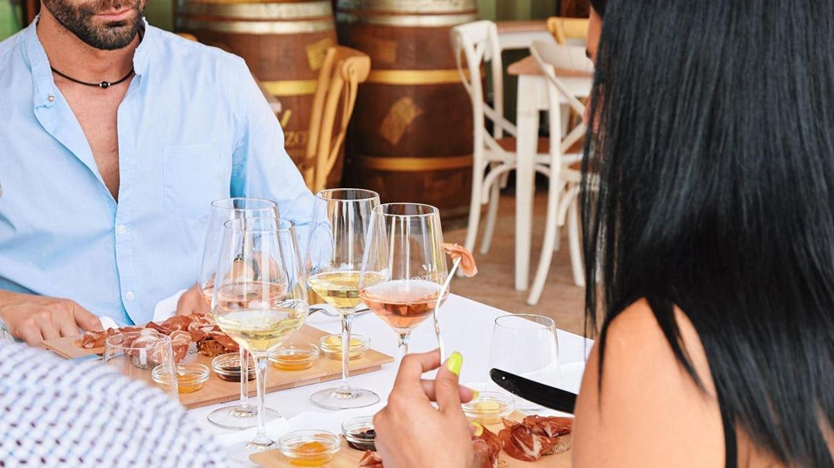 a man and a woman sitting at a table with wine glasses