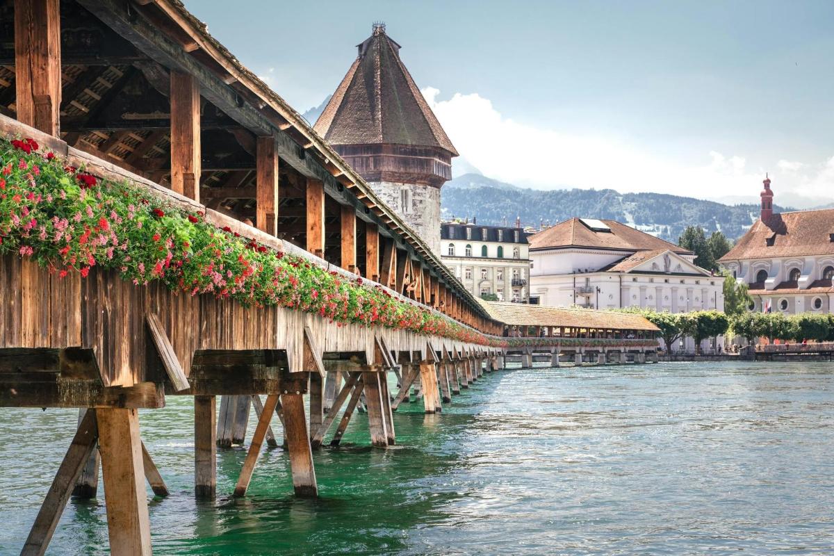 a wooden bridge over a river in a city