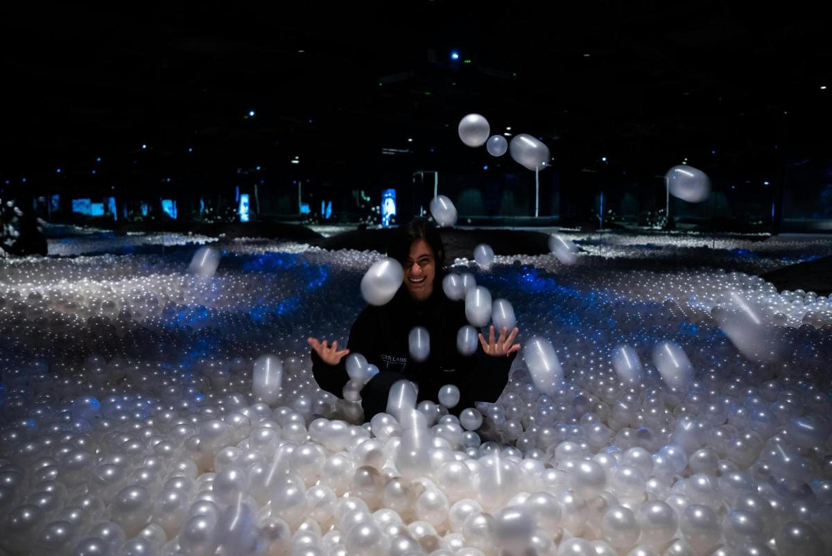 a person sitting in a pool of balls