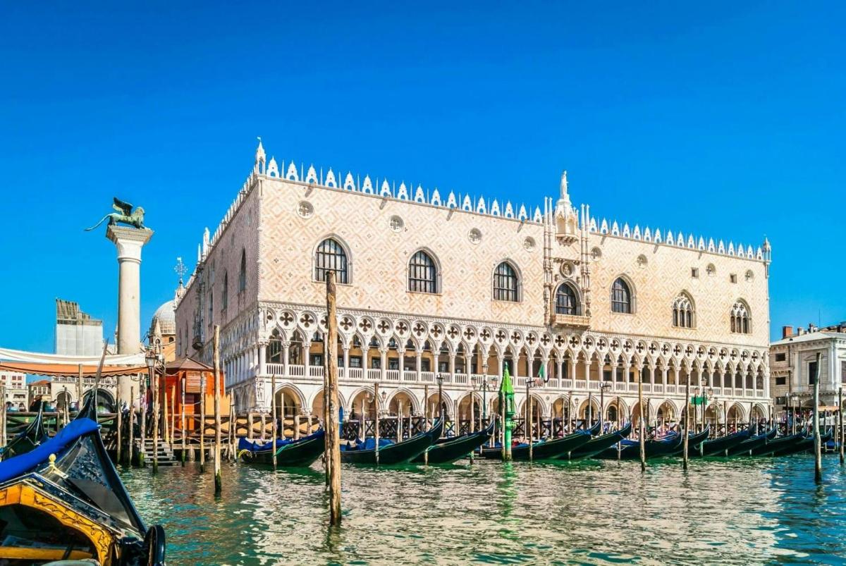 a building with gondolas in the water in front of it