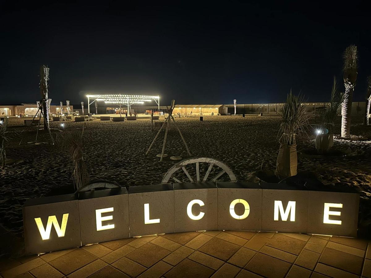 a welcome sign on a beach at night