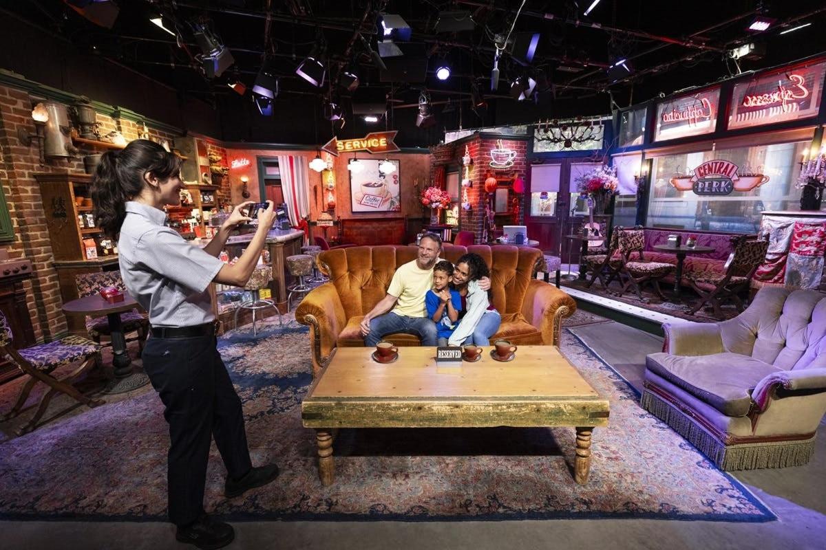 a woman taking a picture of a family in a room