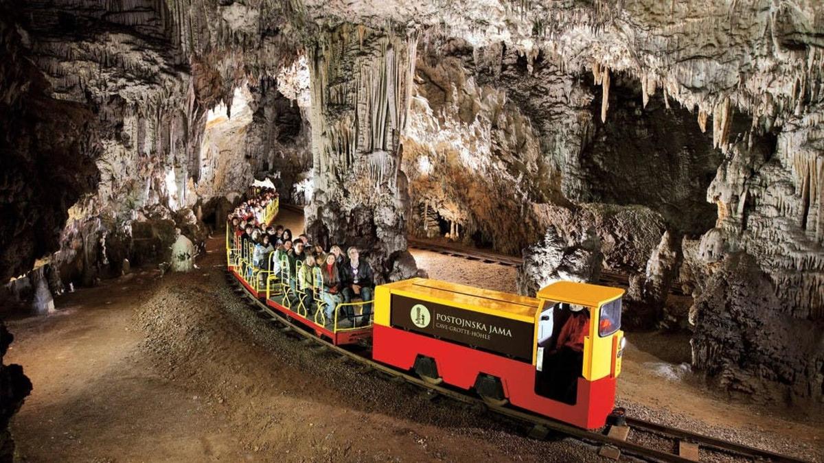 a group of people riding on a train in a cave