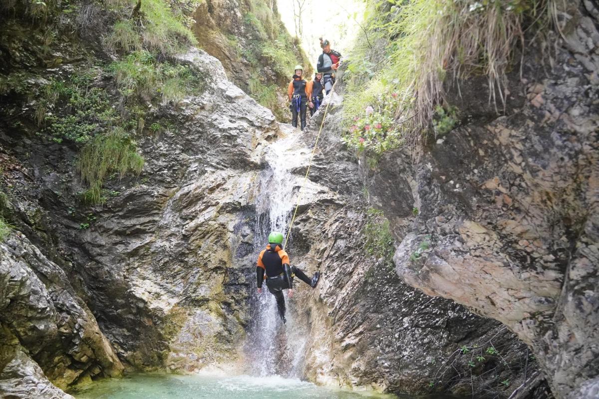 a group of people walking through a waterfall