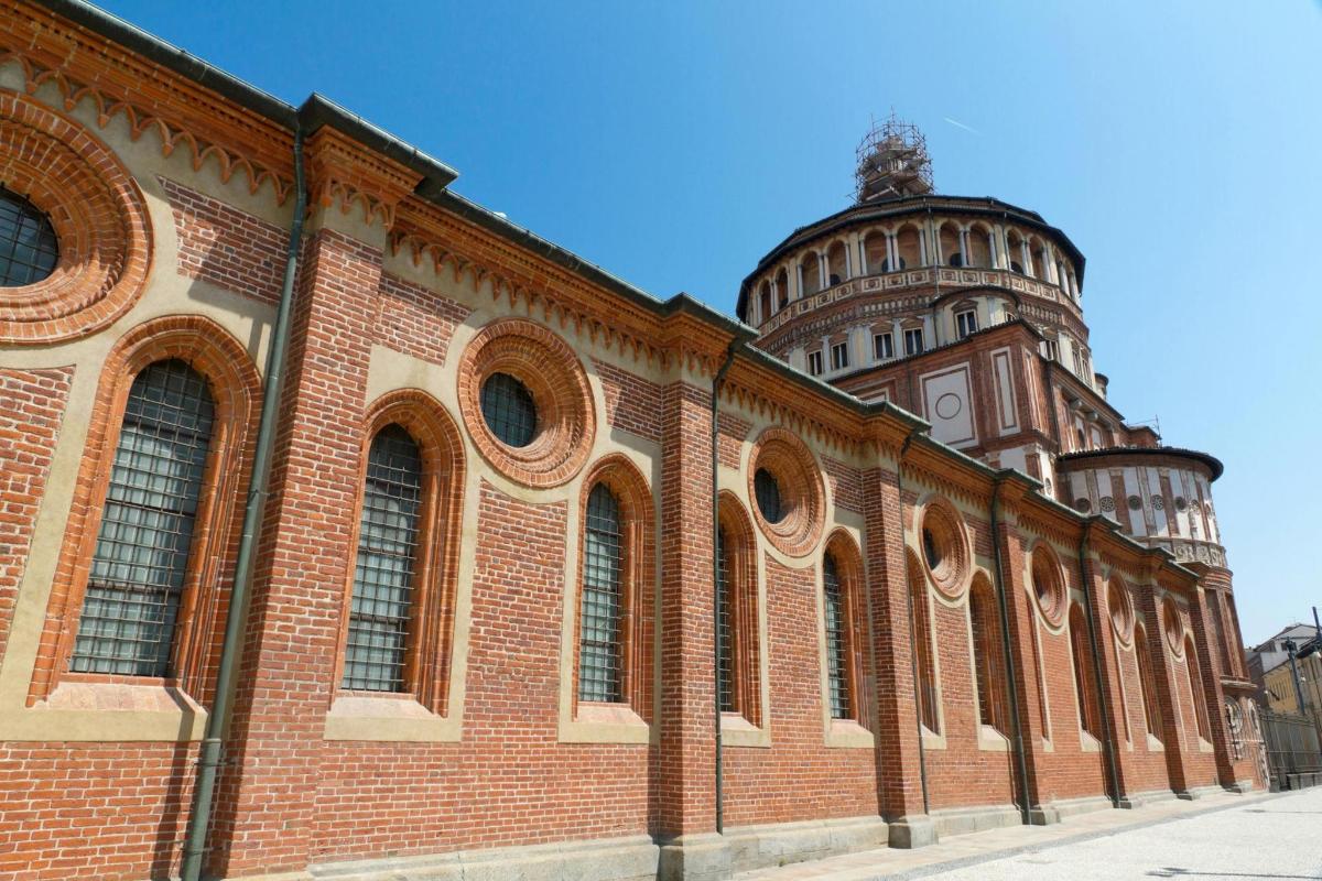 一座大型砖砌建筑，背景是一座塔楼